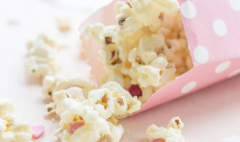 A super easy Valentines Day Gift! Valentines Popcorn made with salted popcorn, melted white chocolate, mini Smarties (M&M´s will do just fine too!) and edible heart confetti | FlavoursandFrosting.com