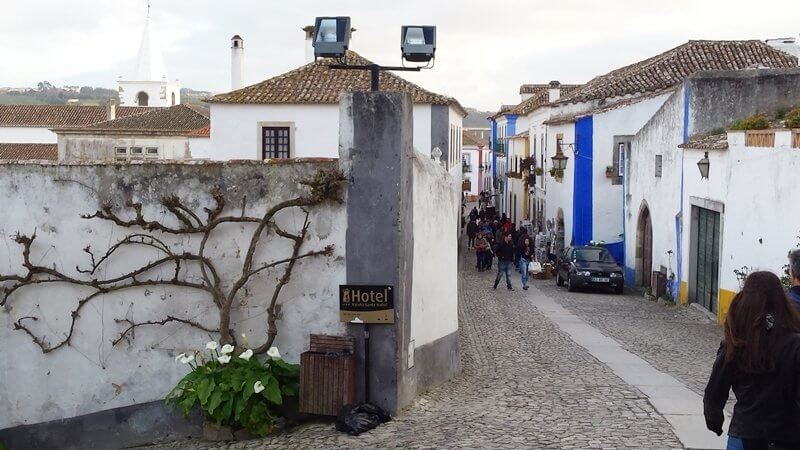 Obidos Portugal - As soon as we arrived to Obidos, I understood (as soon as I saw the castle on the hill) why people love this quaint little village so much. It’ll make you feel like you are in a different time in history altogether. 