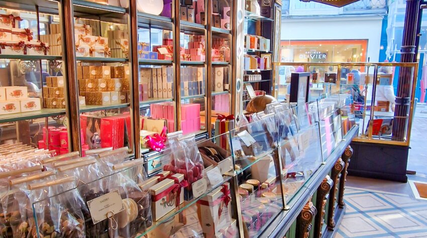 Inside Méert patisserie in Lille France, showcasing a counter filled with gift options including chocolates, biscuits, and other sweet treats.
