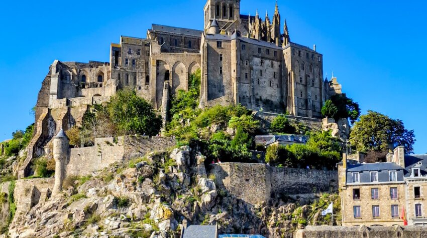 Panoramic view of Mont Saint Michel, France, with its medieval abbey rising above the sea at high tide.