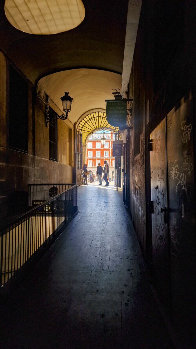 Best Places to eat in Madrid: Breakfast, Brunch, Lunch, Tapas & Dinner Guide Alley way leading to a famous square in Madrid called Plaza Mayor