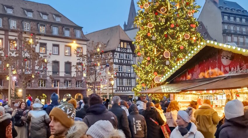 The image captures the festive atmosphere of the famous Strasbourg Christmas Market, also known as the Christkindelsmärik, in France. This market is one of the oldest in Europe, dating back to 1570, and the city is often called the "Capital of Christmas"