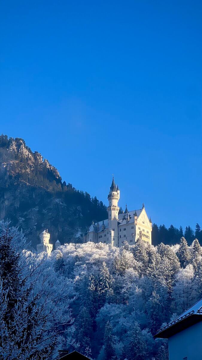 The castle pictured is the Neuschwanstein Castle, located in the Bavarian Alps of Germany. It is one of the world's most famous and picturesque castles, often referred to as a "fairytale castle," especially when covered in snow.