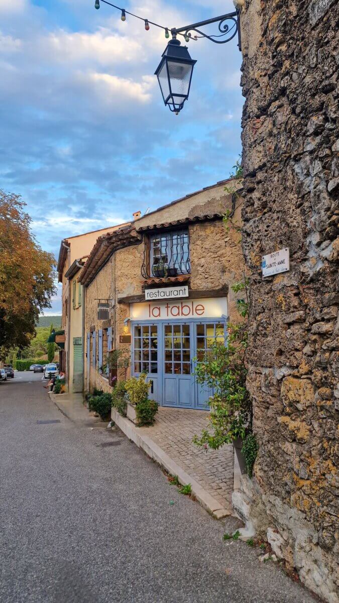 The image shows the exterior of a restaurant called "La Table" located in the village of Tourtour, France