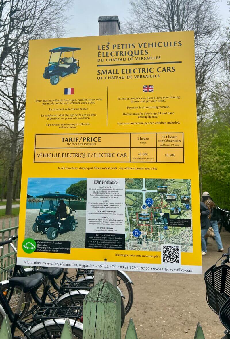 This sign provides information and pricing for renting small electric vehicles at the Château de Versailles to explore the gardens