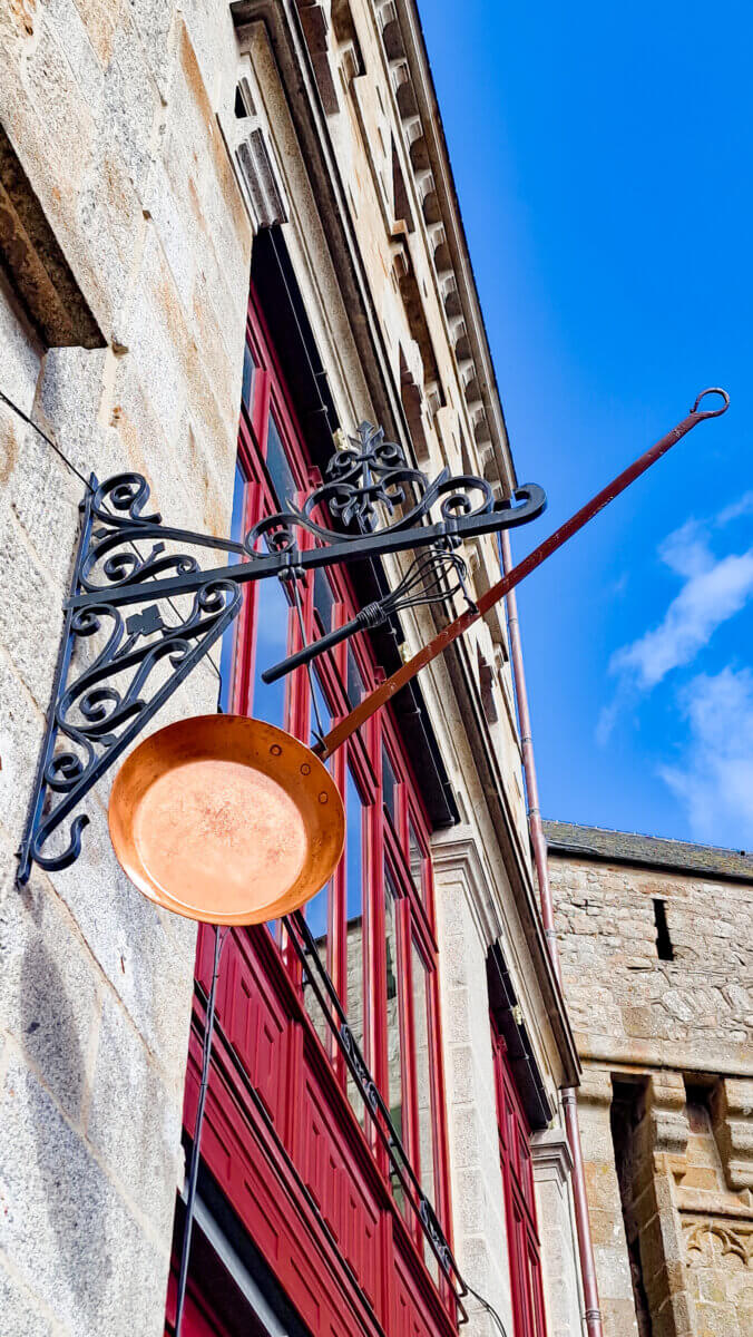 This is the iconic signage for La Mère Poulard restaurant in Mont Saint-Michel, known worldwide for its fluffy wood-fired omelets.