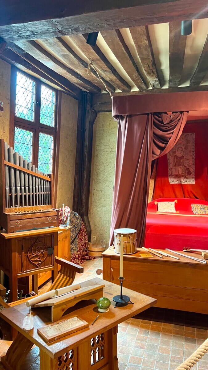 This image depicts a re-creation of a medieval bedroom or chamber, often found in historical castles and museums.