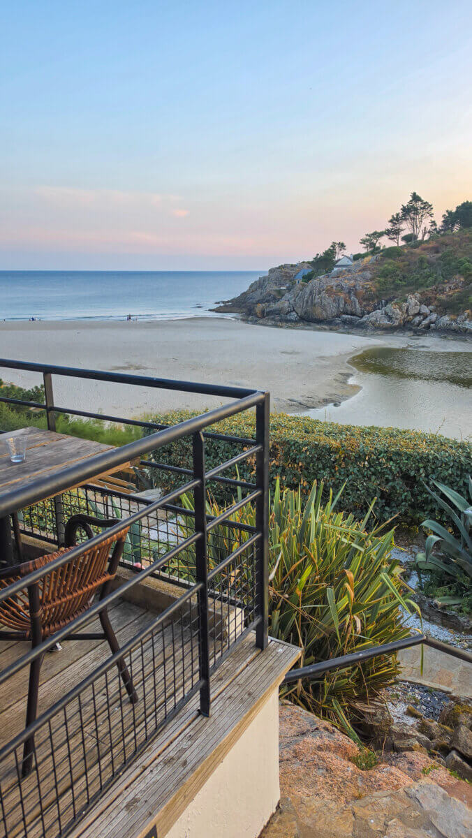 This scenic coastal view overlooks the sandy shore and tidal inlet of the Anse de Rospico in Névez, France