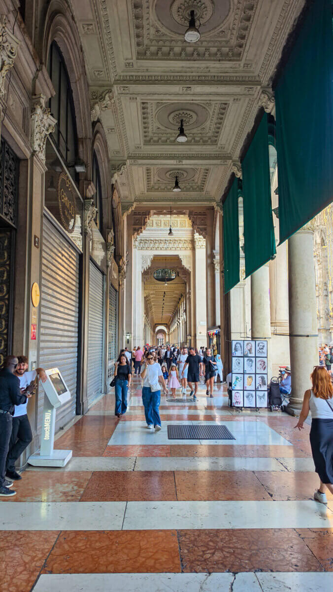 This image shows the grand interior corridor of the Galleria Vittorio Emanuele II in Milan, Italy