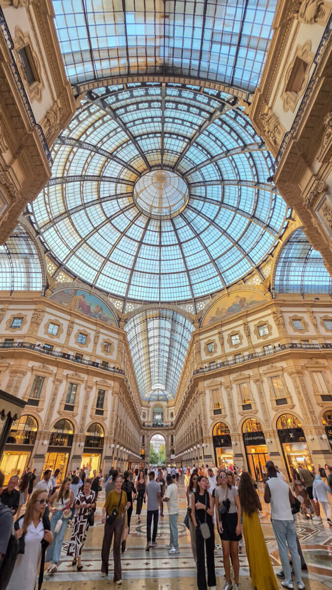 This image shows the grand interior and glass dome of the Galleria Vittorio Emanuele II in Milan, Italy
